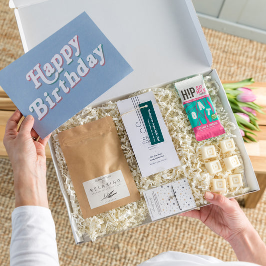 Happy Letterbox Gift Co. | Vegan Large Happy Birthday Gift Box. Including our relaxing Lavender Epsom bath salts, HIP vegan chocolate, Bergamot and Lemongrass plant wax melts, vegan friendly hot chocolate flakes and a choice of a friendship bracelet or star earrings.